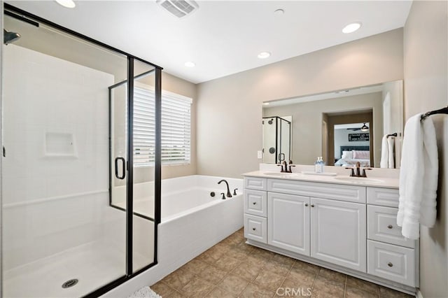 bathroom featuring visible vents, double vanity, a stall shower, a garden tub, and connected bathroom