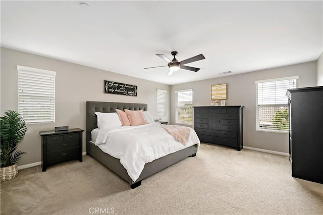 bedroom with a ceiling fan, baseboards, visible vents, and light carpet