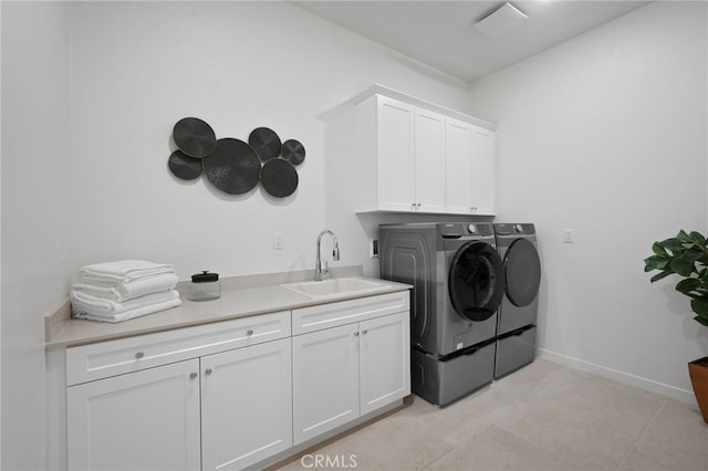 laundry area with independent washer and dryer, a sink, cabinet space, light tile patterned flooring, and baseboards