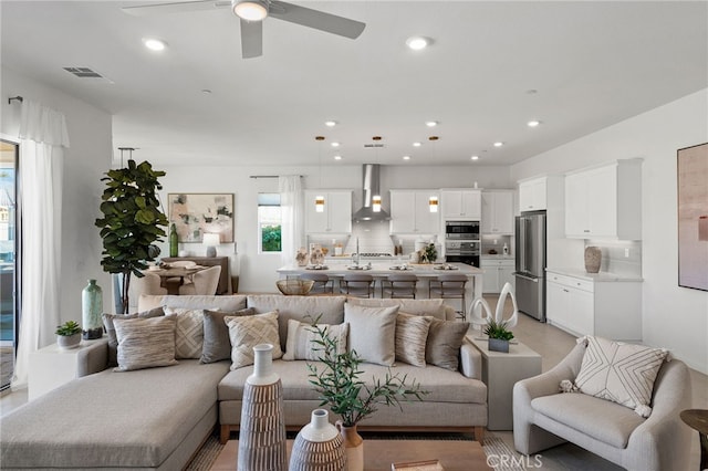 living area with recessed lighting, visible vents, and ceiling fan