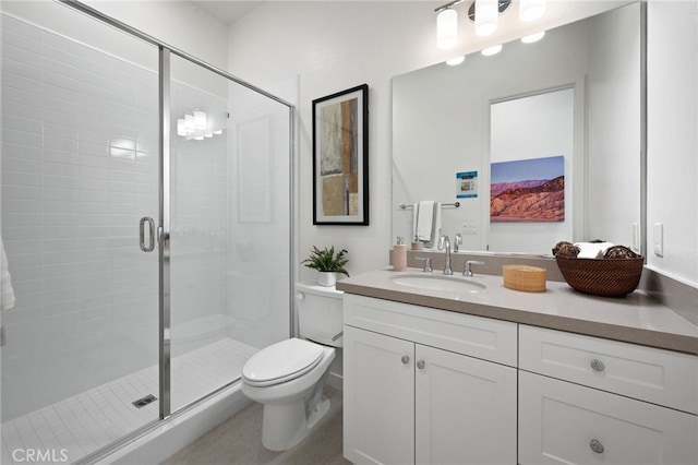 bathroom with vanity, a shower stall, and toilet