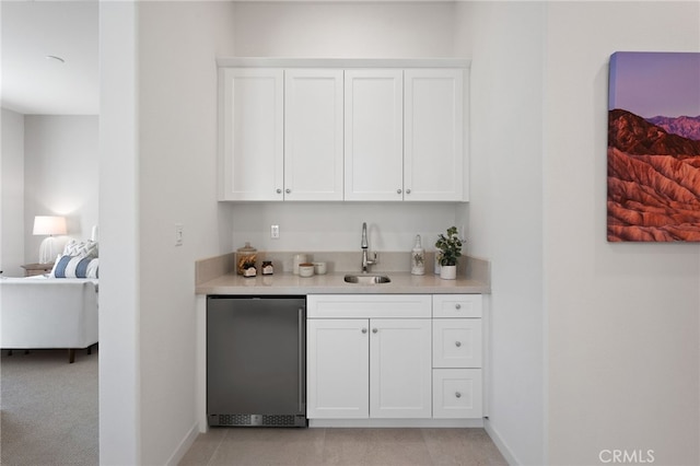 bar with refrigerator, wet bar, baseboards, and a sink