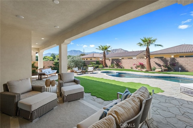 view of patio / terrace with outdoor lounge area, a fenced in pool, a fenced backyard, and a mountain view