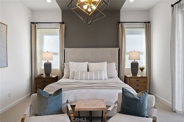 carpeted bedroom featuring an inviting chandelier, multiple windows, and baseboards