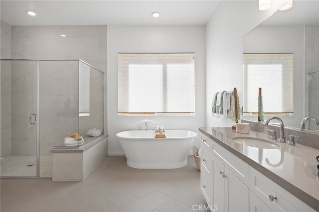 full bathroom with recessed lighting, a marble finish shower, tile patterned flooring, a soaking tub, and vanity