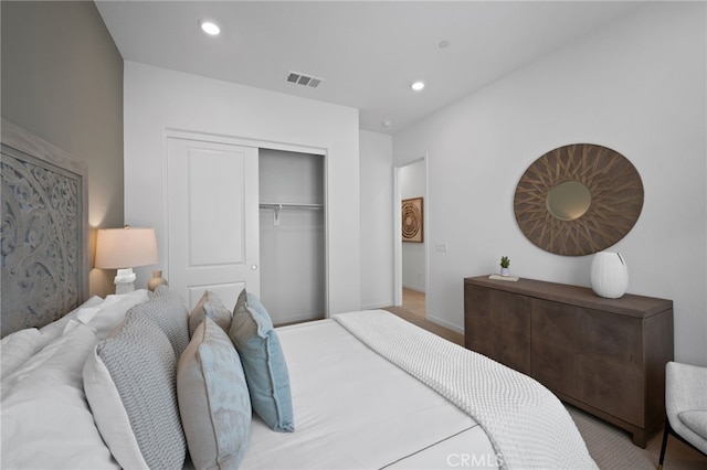 bedroom with a closet, visible vents, recessed lighting, and carpet