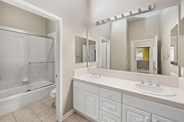 full bathroom with tile patterned flooring, double vanity, toilet, and a sink