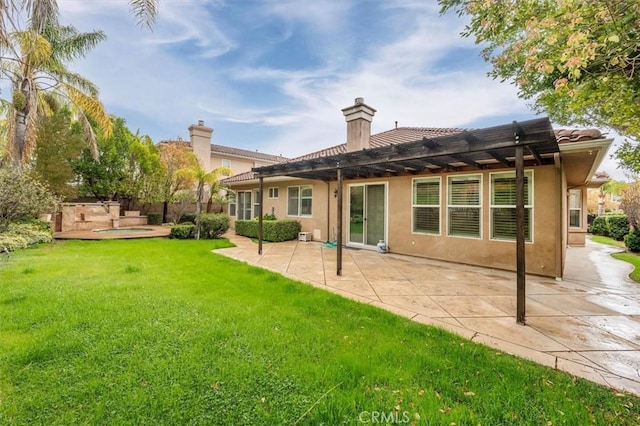 back of property with a yard, a patio area, a chimney, and stucco siding