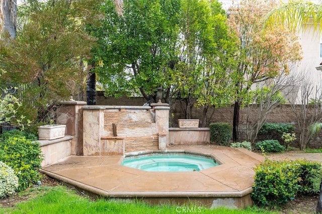 view of pool with an in ground hot tub and fence