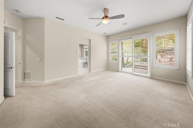 spare room with a ceiling fan, visible vents, and light carpet