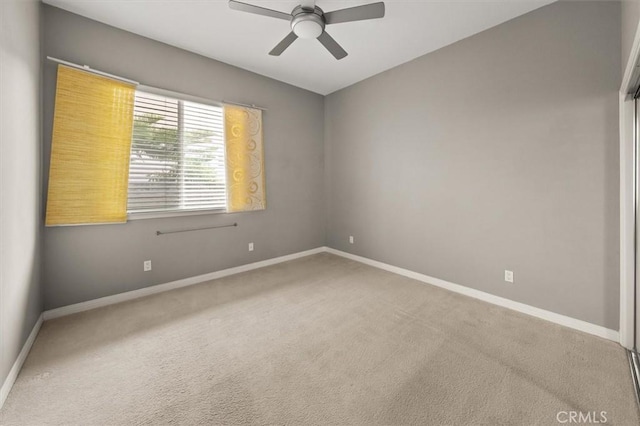 empty room featuring carpet, baseboards, and ceiling fan