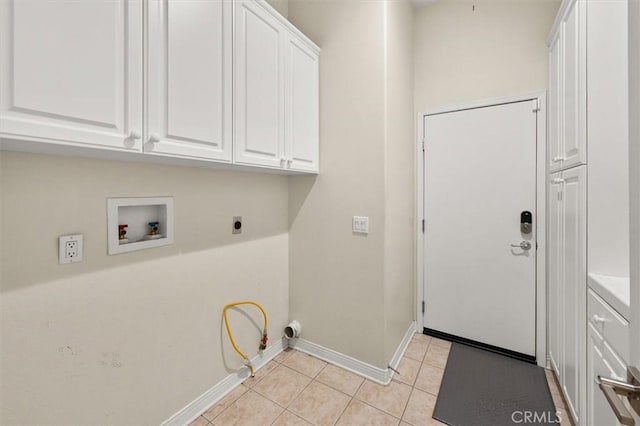 clothes washing area with baseboards, light tile patterned floors, hookup for a washing machine, cabinet space, and electric dryer hookup