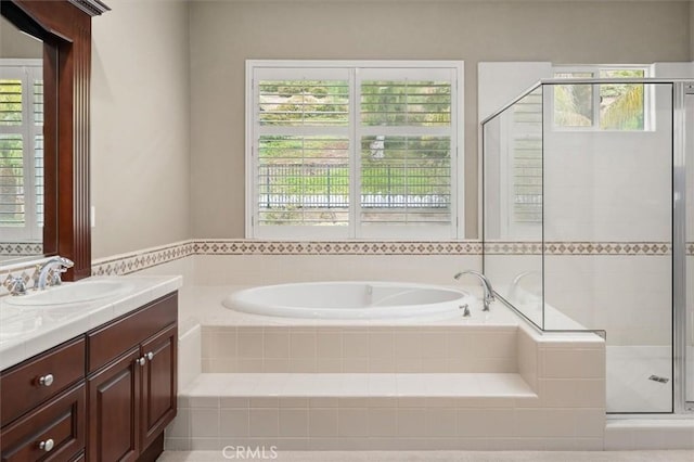 bathroom with a bath, a shower stall, vanity, and a healthy amount of sunlight