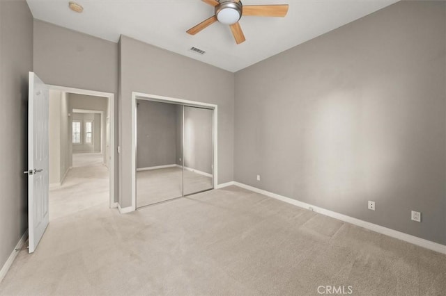 unfurnished bedroom featuring baseboards, visible vents, light carpet, and a closet