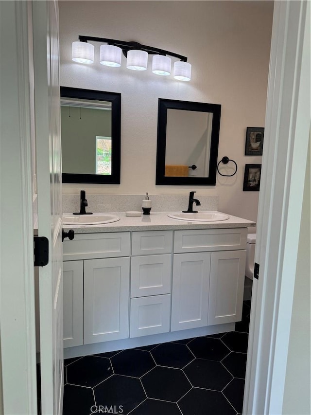 full bath with tile patterned floors, toilet, double vanity, and a sink