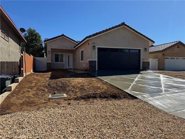 single story home featuring stucco siding, an attached garage, driveway, and fence