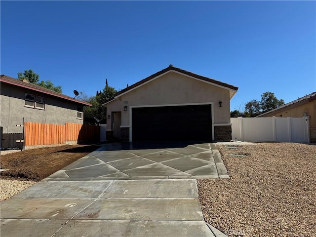 view of front of house featuring an outdoor structure, fence, driveway, and stucco siding