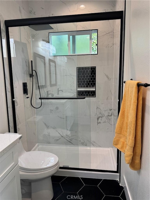 bathroom with a marble finish shower, toilet, vanity, and tile patterned flooring