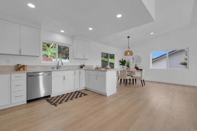 kitchen featuring light wood-style flooring, a sink, a peninsula, light countertops, and dishwasher