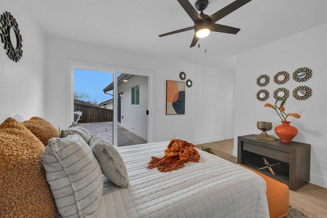 bedroom featuring access to exterior, baseboards, a ceiling fan, and wood finished floors