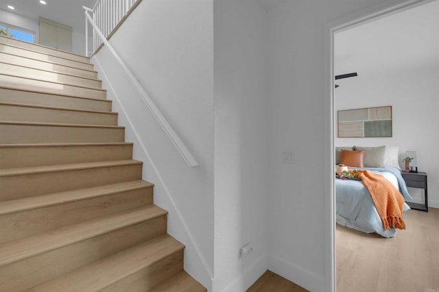 stairway featuring recessed lighting, baseboards, and wood finished floors