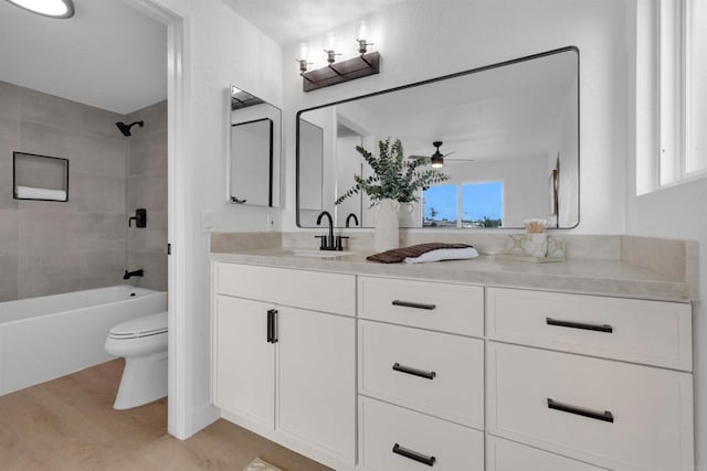 bathroom featuring a wealth of natural light, toilet, wood finished floors, and vanity