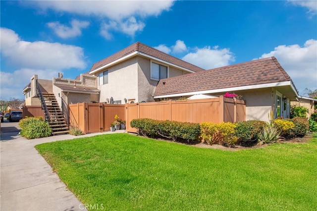 view of yard featuring stairway and fence