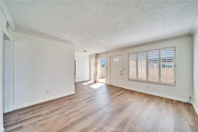 foyer with wood finished floors, baseboards, visible vents, ornamental molding, and a textured ceiling