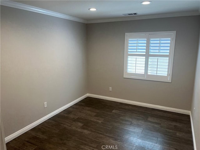 unfurnished room featuring dark wood-type flooring, baseboards, visible vents, and ornamental molding