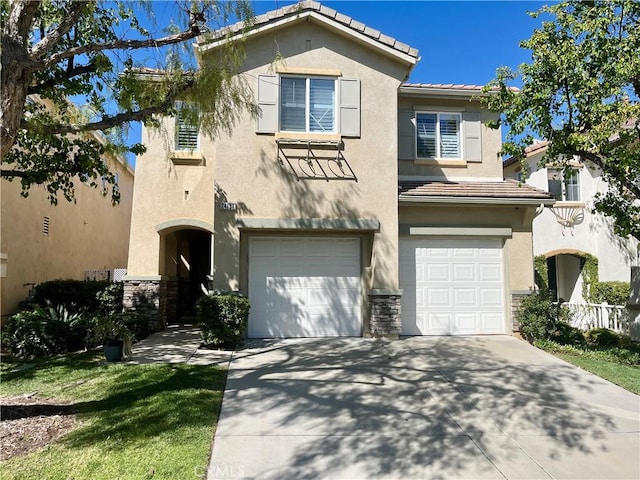 view of front of house featuring stucco siding, a tiled roof, driveway, and a garage