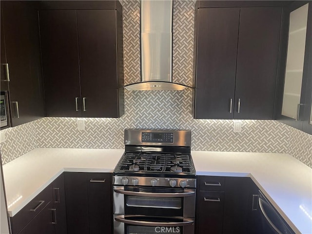 kitchen with double oven range, tasteful backsplash, wall chimney exhaust hood, and light countertops