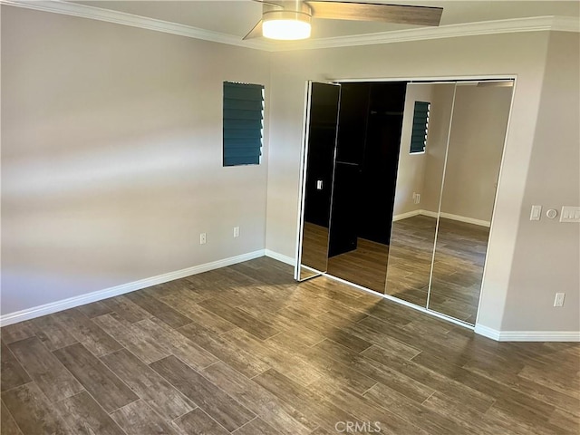 unfurnished bedroom with a closet, crown molding, baseboards, and wood finished floors