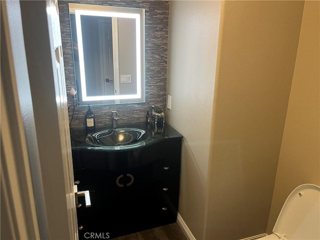 half bathroom with tasteful backsplash and vanity