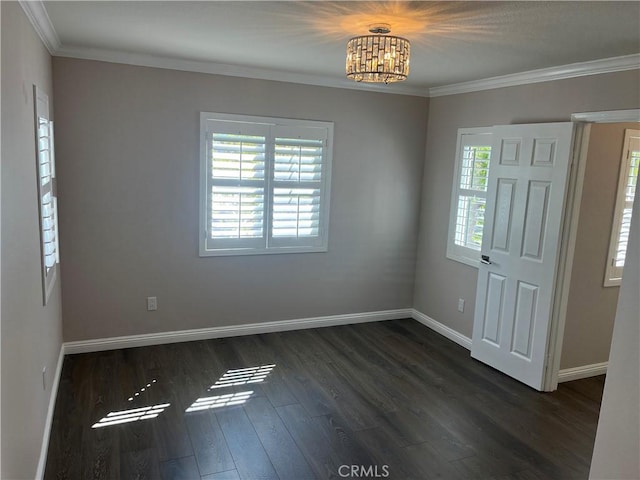 foyer entrance with an inviting chandelier, crown molding, dark wood-type flooring, and baseboards