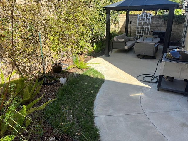 view of patio with a gazebo, fence, and an outdoor living space