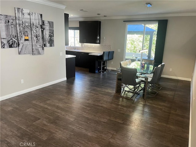 dining area featuring dark wood finished floors, visible vents, crown molding, and baseboards