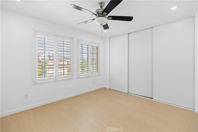 unfurnished bedroom featuring baseboards, ceiling fan, recessed lighting, light wood-style floors, and a closet