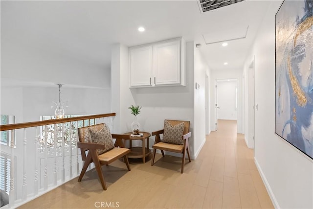 sitting room featuring light wood finished floors, visible vents, baseboards, recessed lighting, and a notable chandelier