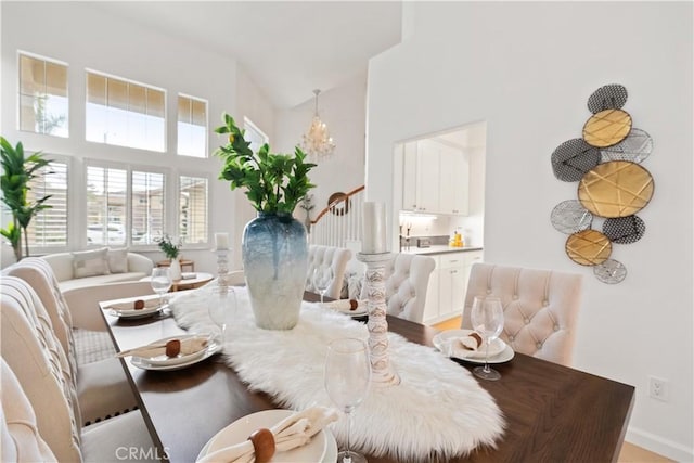 dining area with a notable chandelier, a high ceiling, and stairs