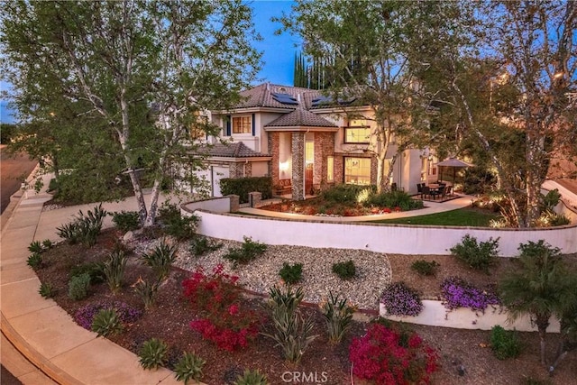 view of front facade featuring solar panels, a patio, a tile roof, and stucco siding