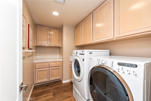 laundry room with washer and clothes dryer, dark wood finished floors, cabinet space, and baseboards