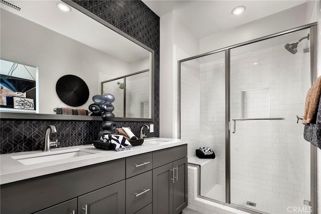 full bathroom featuring visible vents, backsplash, a stall shower, and a sink