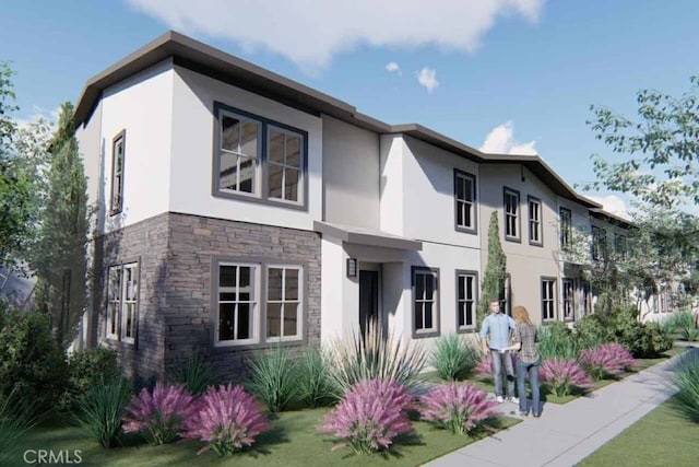 view of front of house featuring stone siding and stucco siding