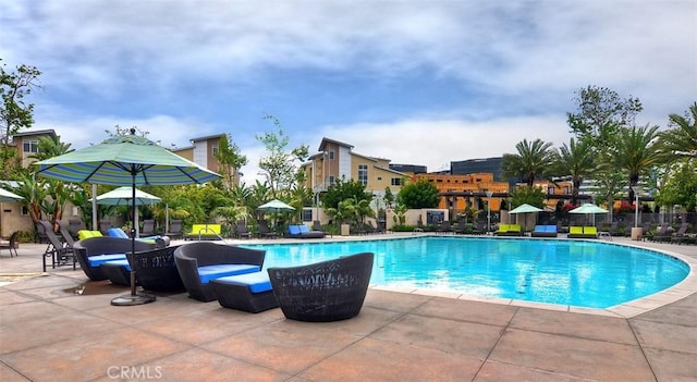 pool with a patio area and fence