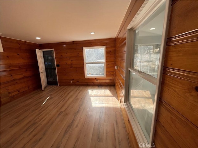 unfurnished room featuring wooden walls, recessed lighting, and wood finished floors