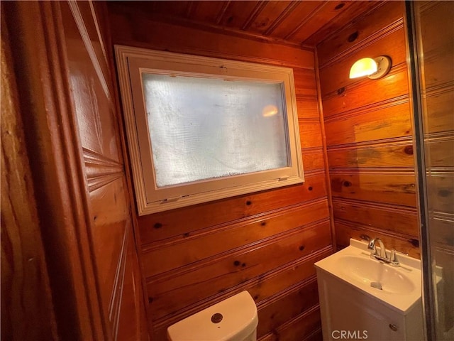 bathroom featuring wood ceiling, wooden walls, toilet, and vanity