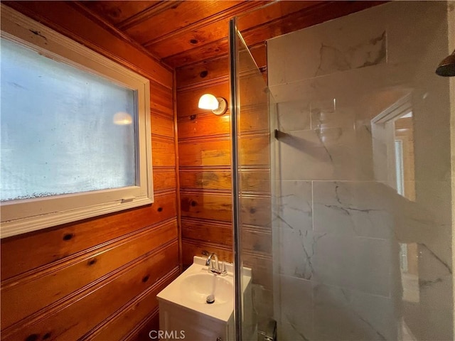 full bathroom with a stall shower, wood ceiling, wood walls, and vanity