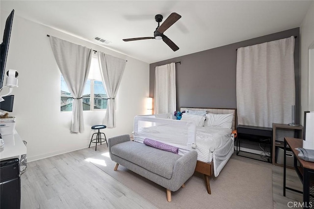 bedroom featuring a ceiling fan, wood finished floors, and visible vents