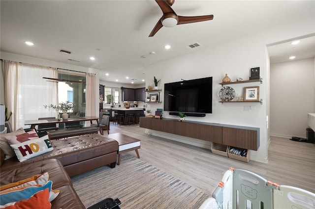 living room featuring light wood-style flooring, recessed lighting, a ceiling fan, and visible vents