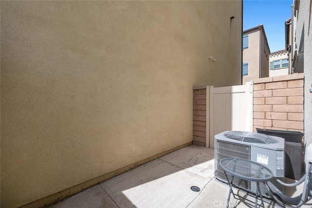 view of patio featuring central AC unit and fence